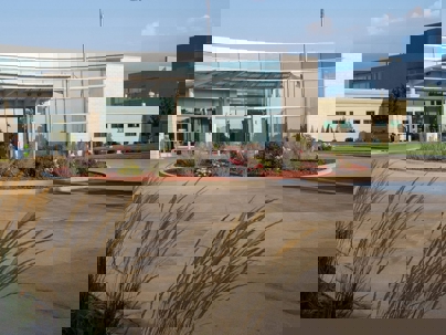 Entrance to a modern medical facility with a curved glass facade.