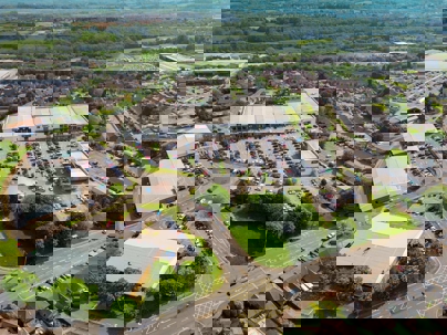 Aerial photo of a suburban shopping center surrounded by well-maintained green spaces.