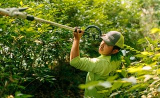 An OakLawn Landscaping employee trims hedges