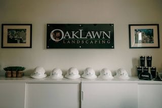 Oaklawn Landscaping company office area, showing the company logo and safety hard hats.