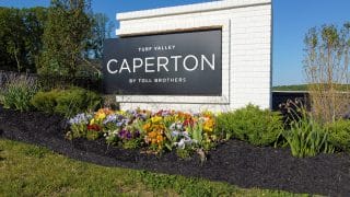 Sign with flowers for Caperton at Turf Valley by Toll Brothers.